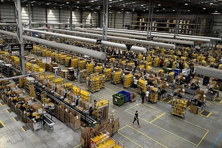 Nhân viên đóng gói hàng hóa cho khách hàng tại một trung tâm dịch vụ của Amazon. Nguồn: TTXVN