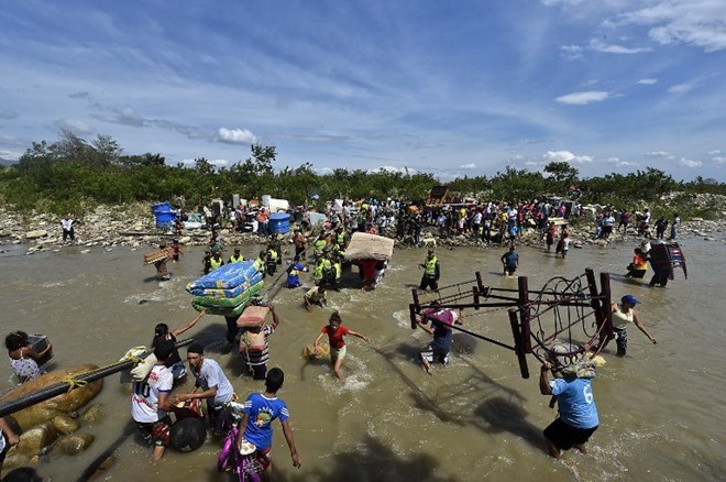 Người di cư Colombia bị phía Venezuela buộc hồi hương tại khu vực sông Tachira, biên giới tự nhiên giữa hai nước, ngày 25/8. (Nguồn: AFP)