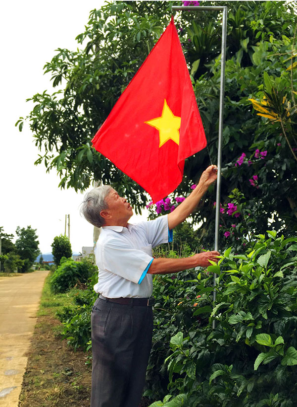 Ông Lưu Đức Tuệ đang treo cờ chuẩn bị cho ngày lễ Quốc khánh mùng 2/9