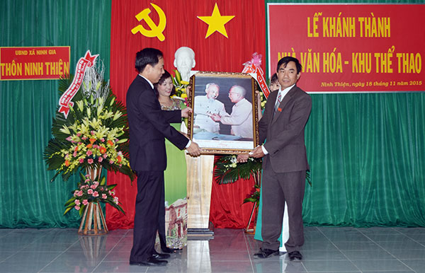 Ông Trần Ngọc Liêm (trái) trao tặng bức ảnh “Bác Hồ với Bác Tôn” cho nhân dân thôn Ninh Thiện