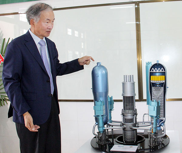 GS Kim Si Hwan bên mô hình mô phỏng lò phản ứng hạt nhân APT1 400 tại phòng thí nghiệm của ĐHDL