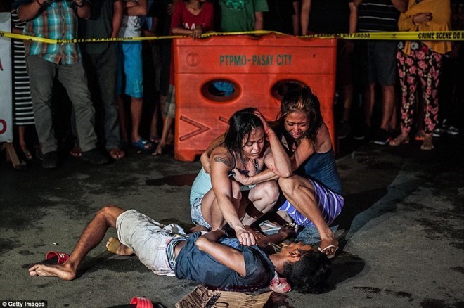 Hai người phụ nữ đau khổ khóc lóc bên xác một nạn nhân bị cho là tội phạm ma túy ở Philippines. (Nguồn: Getty Images)
