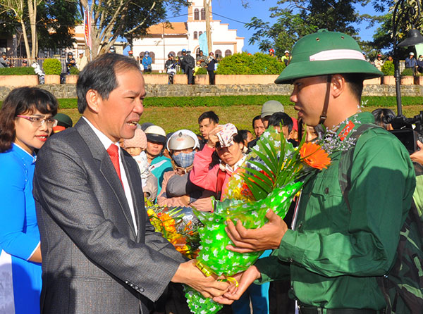 Bí thư Tỉnh ủy Nguyễn Xuân Tiến tặng hoa và động viên các tân binh. Ảnh: BÙI TRƯỞNG