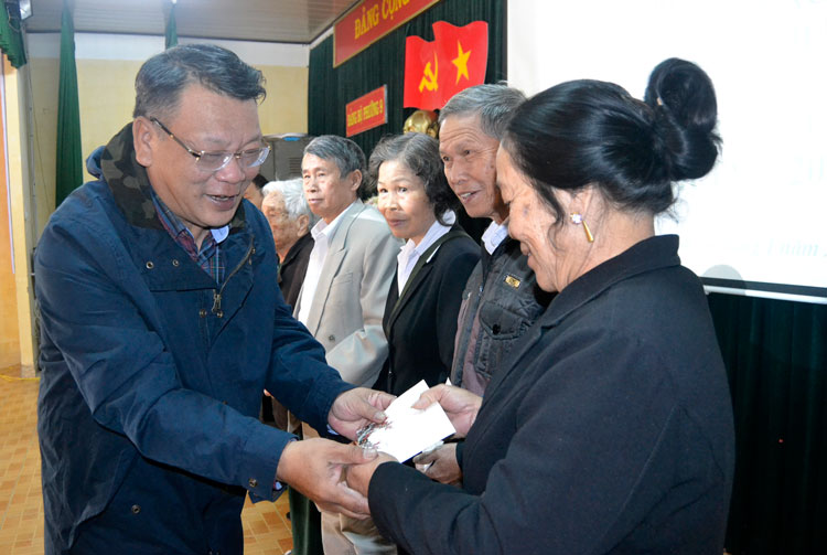 Đồng chí Nguyễn Tạo thay mặt đồng chí Trương Thị Mai tặng quà cho các gia đình người có công