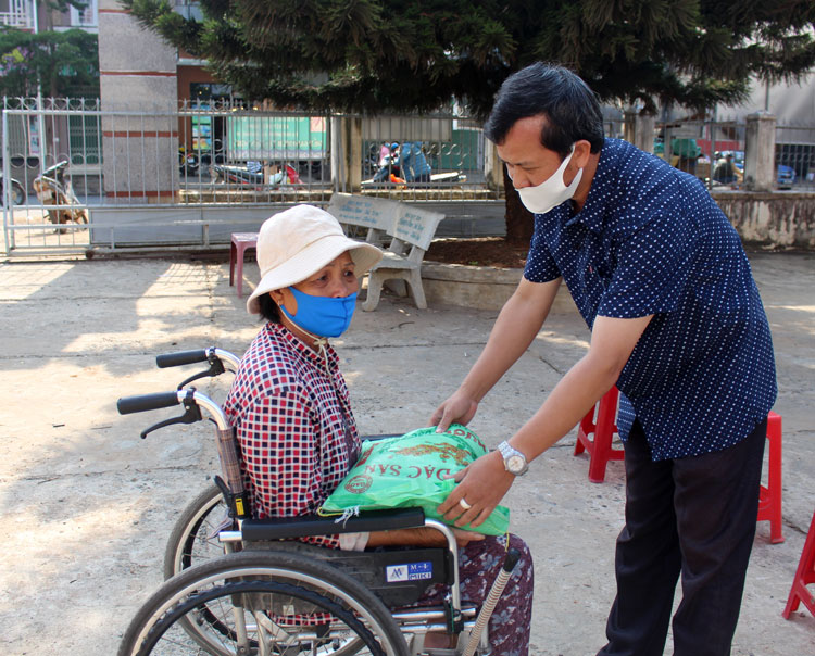 Ông Lê Văn Thiện – Chủ tịch UBND thị trấn Liên Nghĩa, trao quà tận tay người tàn tật