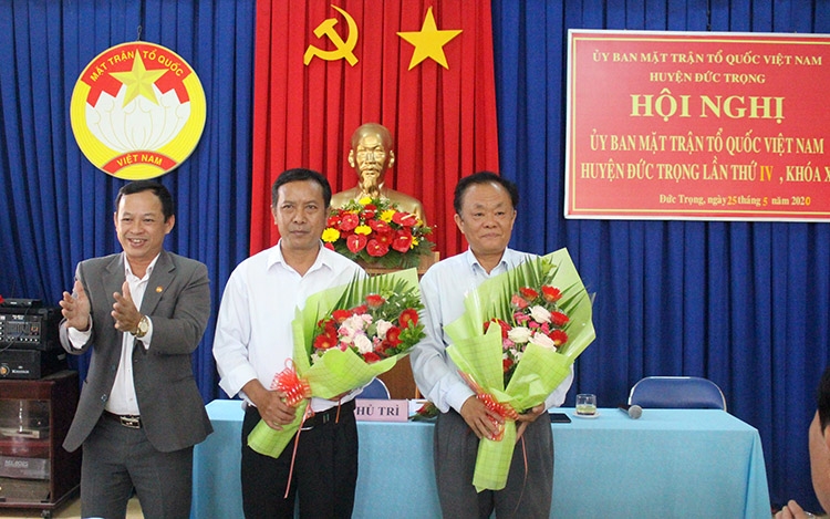 Ông Lê Công Tuấn - Trưởng Ban Dân vận Huyện ủy, Chủ tịch Ủy ban MTTQ Việt Nam huyện, tặng hoa chúc mừng ông Lê Hồng Khánh và ông K’Sói