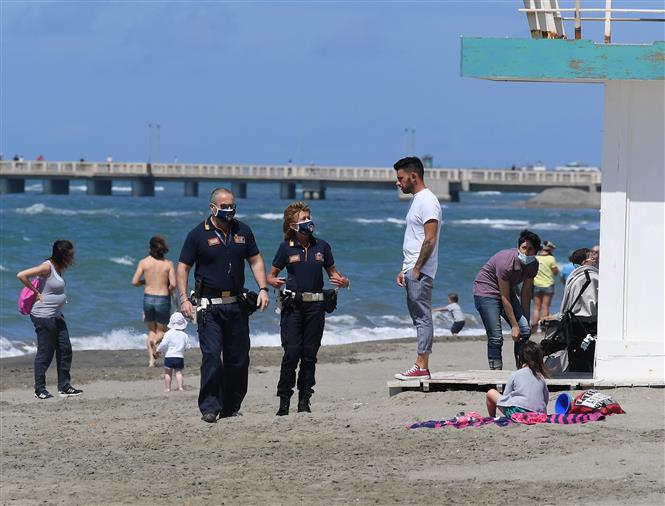  Cảnh sát đeo khẩu trang tuần tra tại bãi biển ở Ostia, Italy, ngày 19/5/2020.