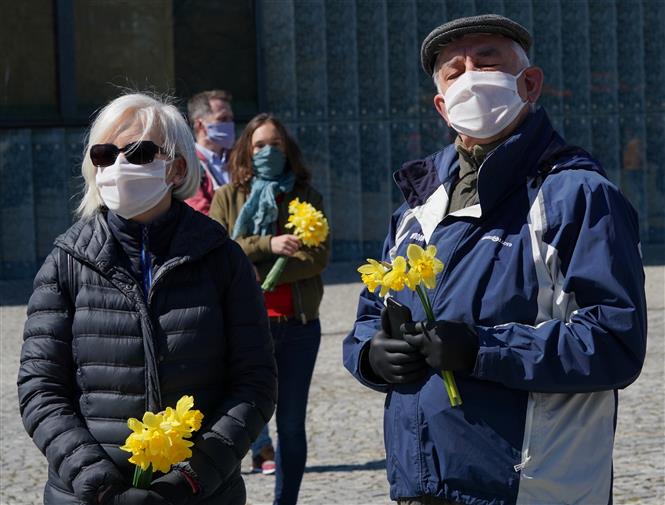 Người dân đeo khẩu trang phòng dịch COVID-19 tại Warsaw, Ba Lan ngày 19/4/2020