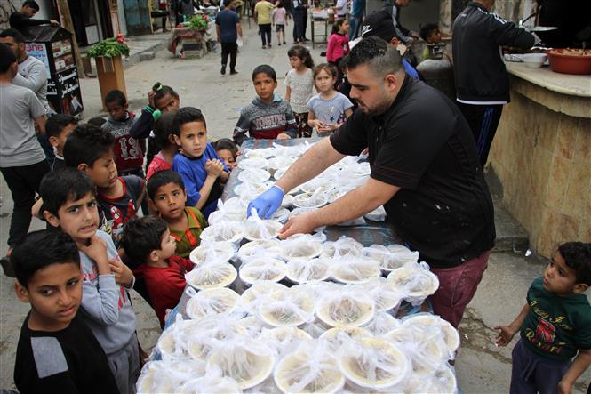  Người Palestine phân phát thức ăn miễn phí nhân tháng lễ Ramadan ở Deir al-Balah, miền Trung Dải Gaza ngày 27/4/2020.