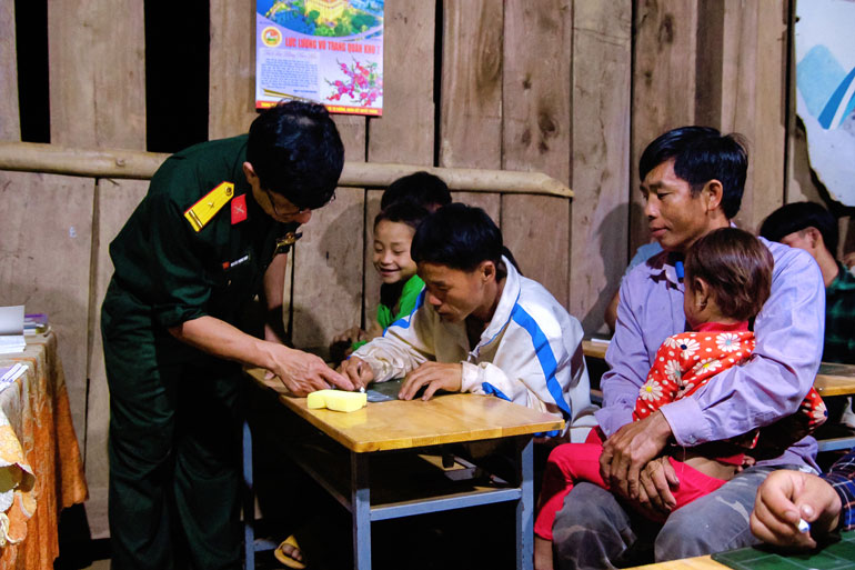 Thiếu tá Nguyễn Trọng Thúy hướng dẫn cho bà con Tiểu khu 179 viết chữ