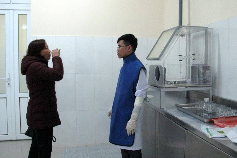 Kỹ sư Khoa Y học hạt nhân (Bệnh viện Đa khoa Lâm Đồng) cho bệnh nhân uống liều I-ốt 131 ngay tại Phòng chiết liều phóng xạ I -131 điều trị bệnh bướu cổ