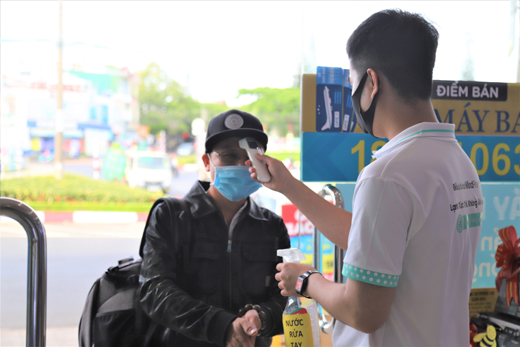 Nhân viên kiểm tra thân nhiệt, sát khuẩn tay cho khách hàng khi đến tham quan, mua sắm tại Siêu thị Điện Máy Xanh Bảo Lộc