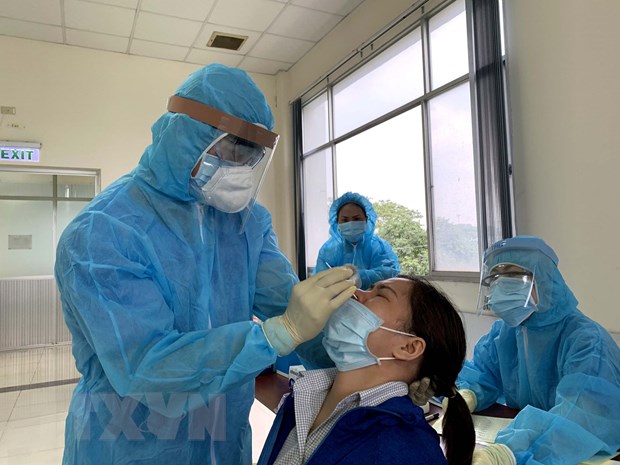 Các y bác sỹ Trung tâm kiểm soát bệnh tật Thành phố Hồ Chí Minh và Quận 7 lấy mẫu xét nghiệm sàng lọc COVID-19 ngẫu nhiên cho công nhân, người lao động trong Khu chế xuất Tân Thuận.