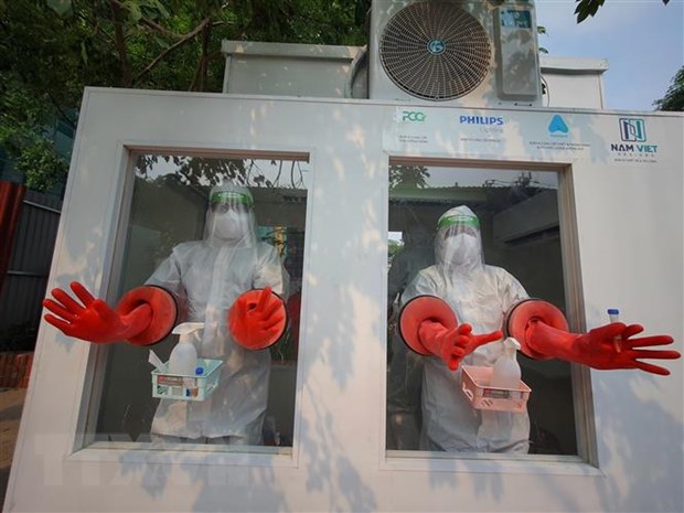 Các nhân viên y tế đang thao tác trước khi tiến hành lấy mẫu trong cabin lấy mẫu xét nghiệm được đưa vào sử dụng tại huyện Tân Yên( Bắc Giang)