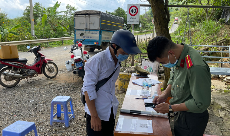 Người dân thực hiện khai báo y tế điện tử tại chốt kiểm soát dịch Ninh Loan (Đức Trọng) giáp huyện Bắc Bình (Bình Thuận) 