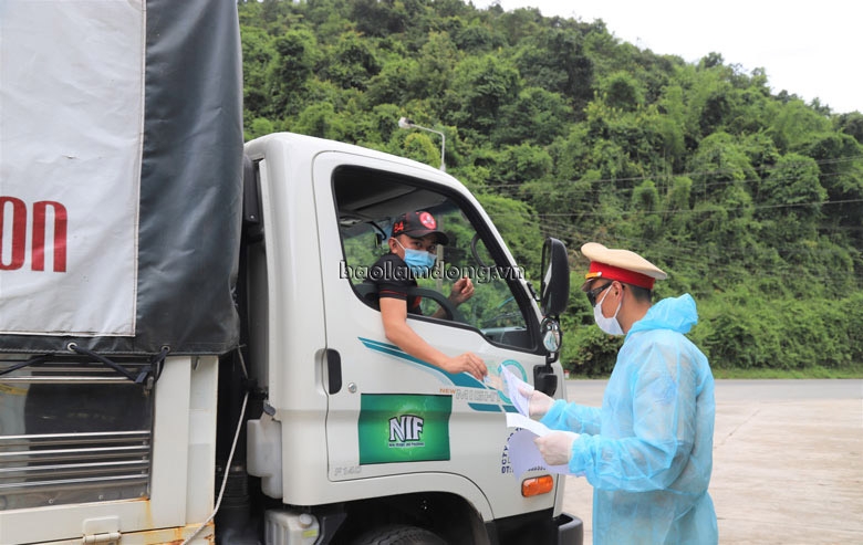 Lực lượng chức năng kiểm tra phiếu xác nhận đã khai báo y tế để người dân qua chốt đèo Chuối. Ảnh: Khánh Phú