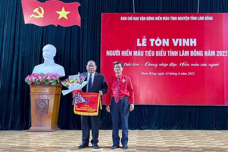 Ông Nguyễn Quang Minh - Chủ tịch Hội CTĐ tỉnh trao cờ lưu niệm cho lãnh đạo huyện Đam Rông